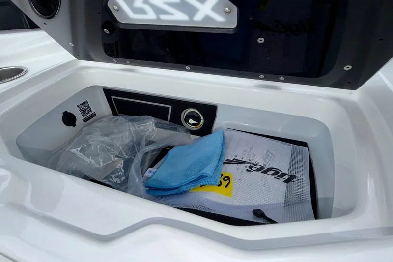Slide: The Image of Storage compartment of 2027 Tigé 24RZX boat with cleaning supplies and accessories. - 34