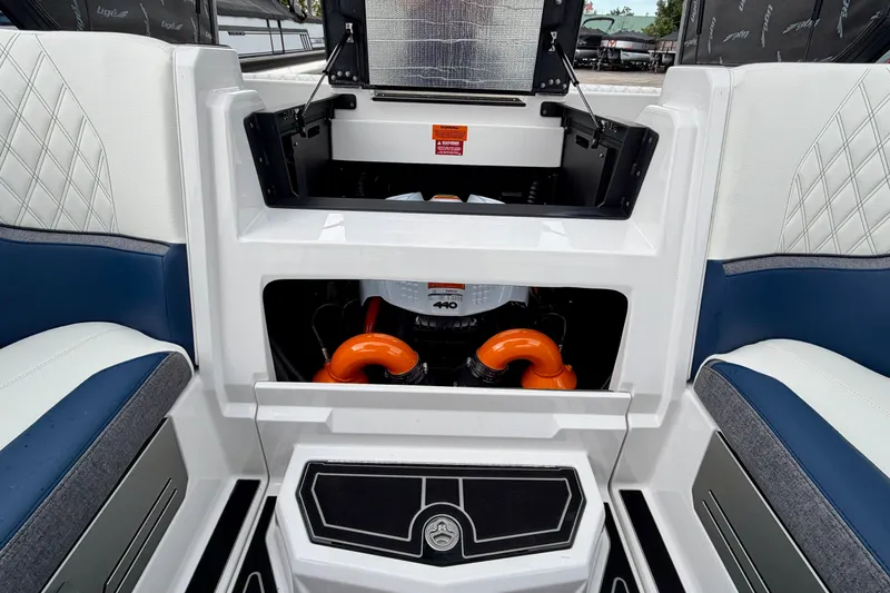 Slide: The Image of 2027 Tigé 24RZX boat interior showing engine compartment with orange accents. - 18