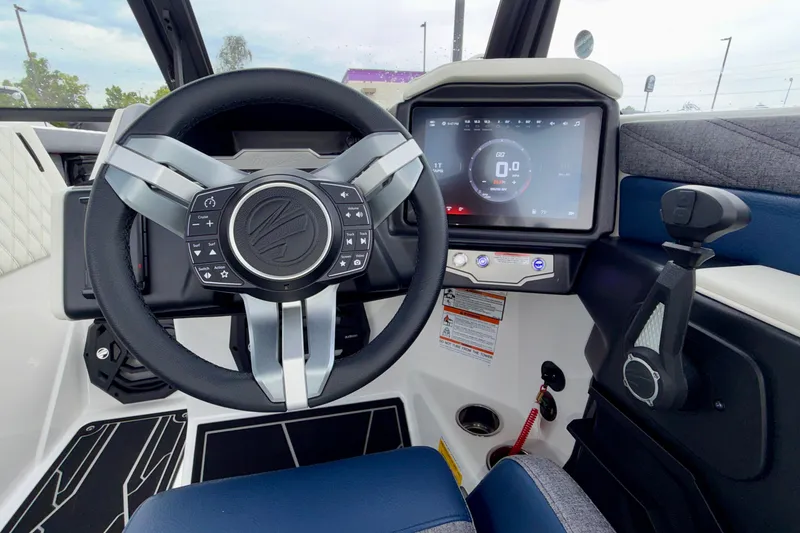 Slide: The Image of 2027 Tigé 24RZX boat dashboard with steering wheel and touchscreen display. - 39