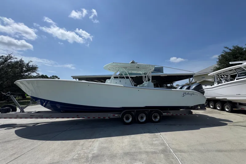 The Image of 2014 Yellowfin 39 Offshore boat on trailer under clear blue sky. - 1
