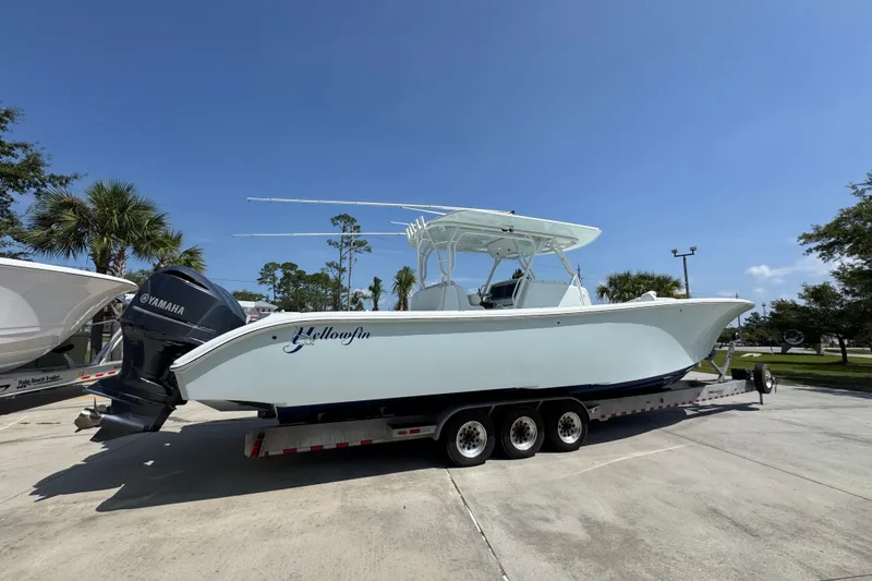 Slide: The Image of 2014 Yellowfin 39 Offshore boat on trailer, parked outdoors under clear blue sky. - 15