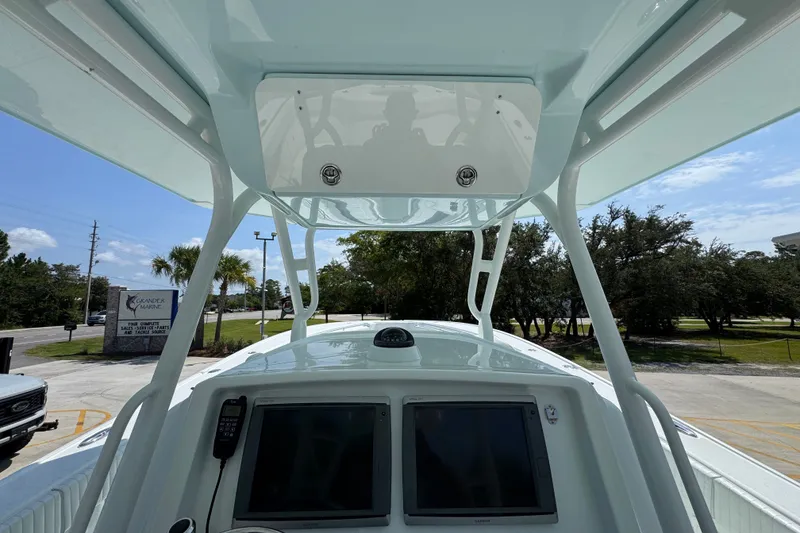 Slide: The Image of 2014 Yellowfin 39 Offshore boat console with electronics and canopy, parked outdoors. - 37