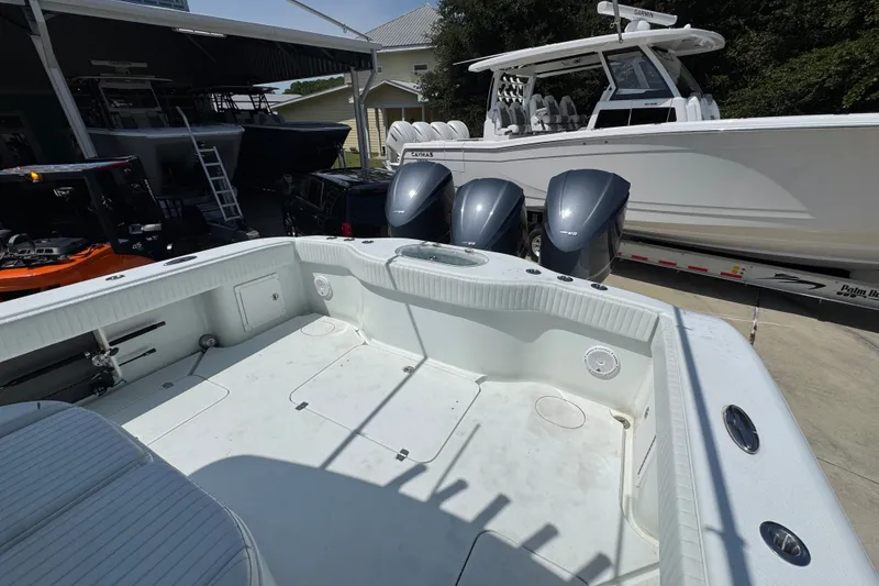 Slide: The Image of 2014 Yellowfin 39 Offshore boat with triple outboard engines, docked near a trailer. - 42