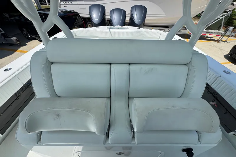 Slide: The Image of 2014 Yellowfin 39 Offshore boat with white cushioned seating and triple outboard motors. - 32