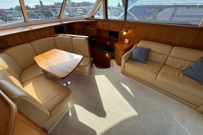 Slide: The Image of Luxurious interior of a 2000 Silverton 42 Convertible yacht with beige seating and wooden accents. - 18