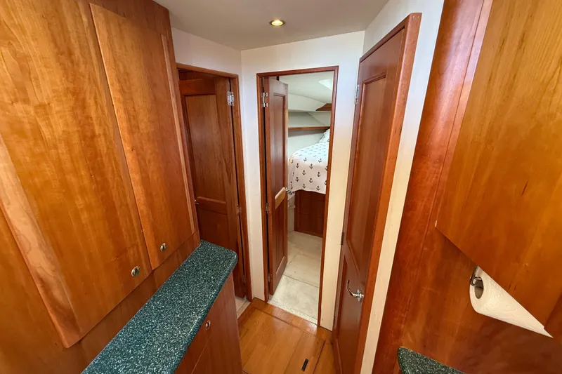 Slide: The Image of Interior hallway of 2000 Silverton 42 Convertible yacht with wood cabinetry and bedroom view. - 31