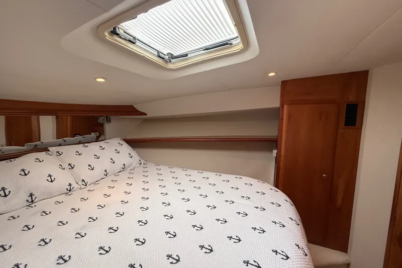 Slide: The Image of Cozy cabin interior of 2000 Silverton 42 Convertible yacht with anchor-patterned bedding. - 37