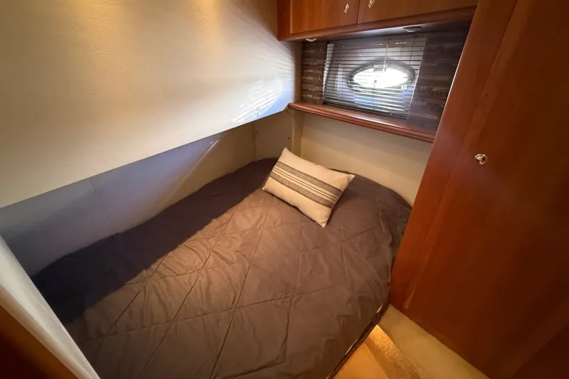 Slide: The Image of Cozy cabin interior of 2000 Silverton 42 Convertible yacht with bed and porthole window. - 32