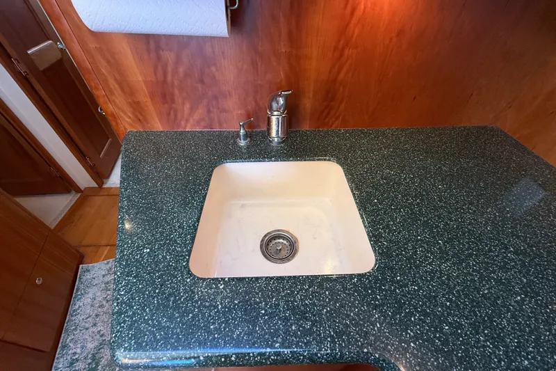 Slide: The Image of Kitchen sink with green speckled countertop in 2000 Silverton 42 Convertible boat. - 26