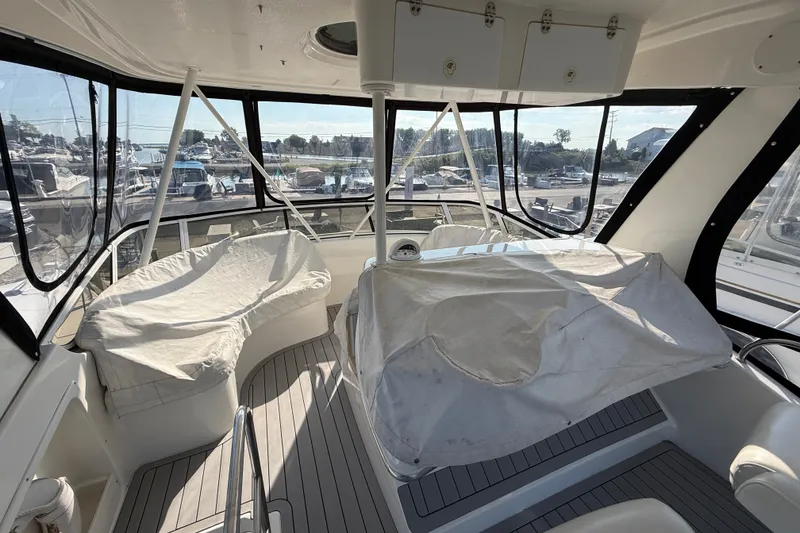 Slide: The Image of Interior view of a 2000 Silverton 42 Convertible yacht with covered seating and panoramic windows. - 47