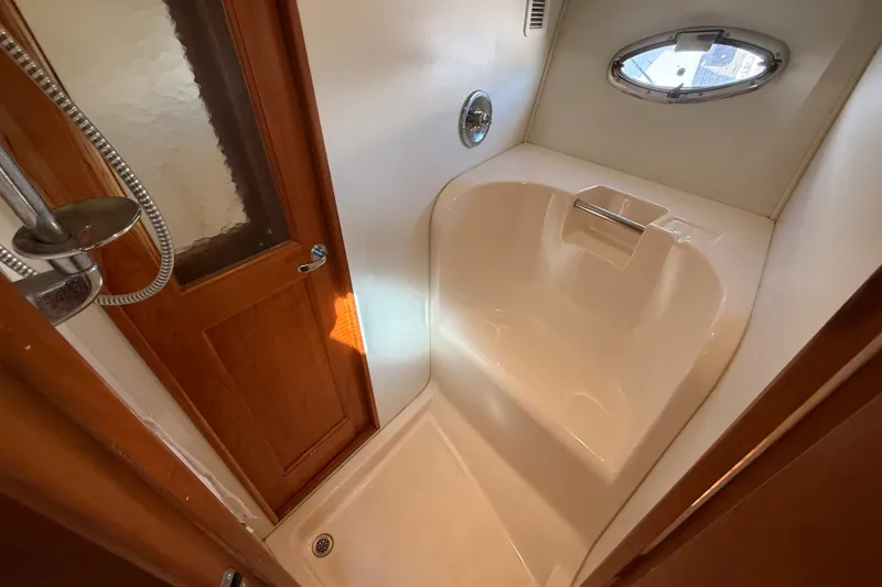 Slide: The Image of Shower area in 2000 Silverton 42 Convertible yacht with wooden door and porthole window. - 41