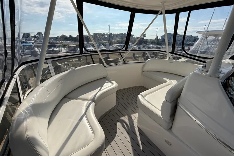 Slide: The Image of Interior view of a 2000 Silverton 42 Convertible yacht with white seating. - 48