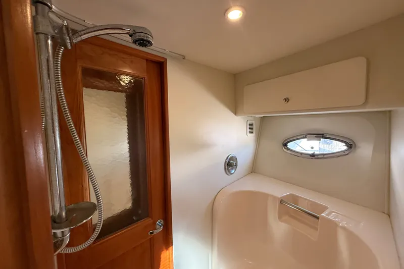 Slide: The Image of Bathroom interior of 2000 Silverton 42 Convertible yacht with shower and porthole window. - 40