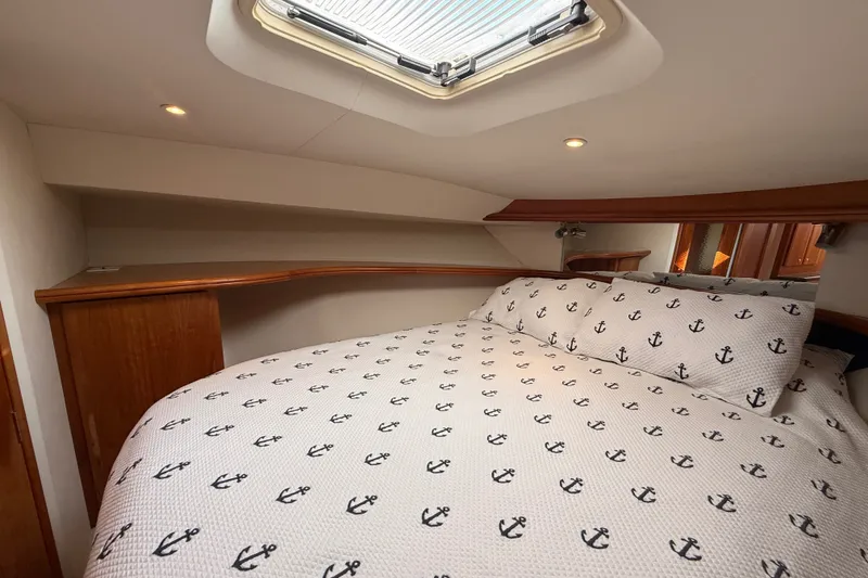 Slide: The Image of Cozy cabin interior of 2000 Silverton 42 Convertible yacht with anchor-patterned bedding. - 36