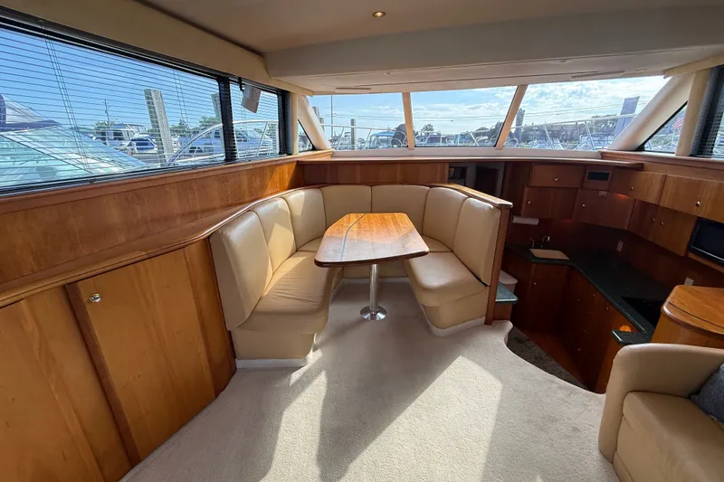 Slide: The Image of Interior of 2000 Silverton 42 Convertible yacht with wood paneling and beige seating. - 15