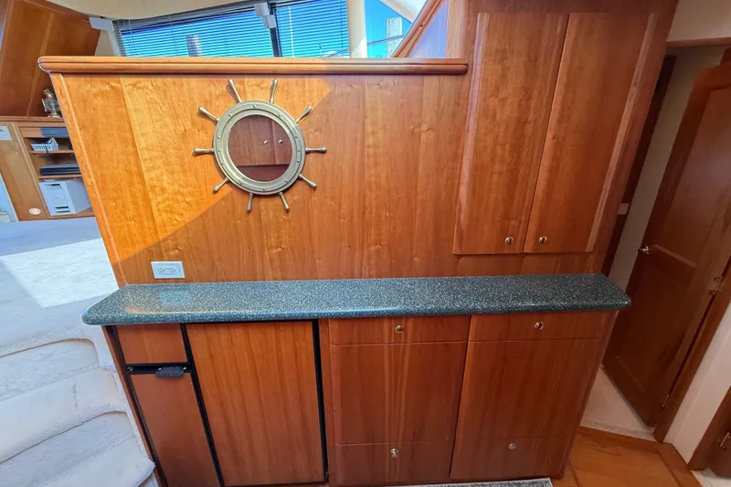 Slide: The Image of Interior of 2000 Silverton 42 Convertible yacht with wooden cabinetry and nautical decor. - 28