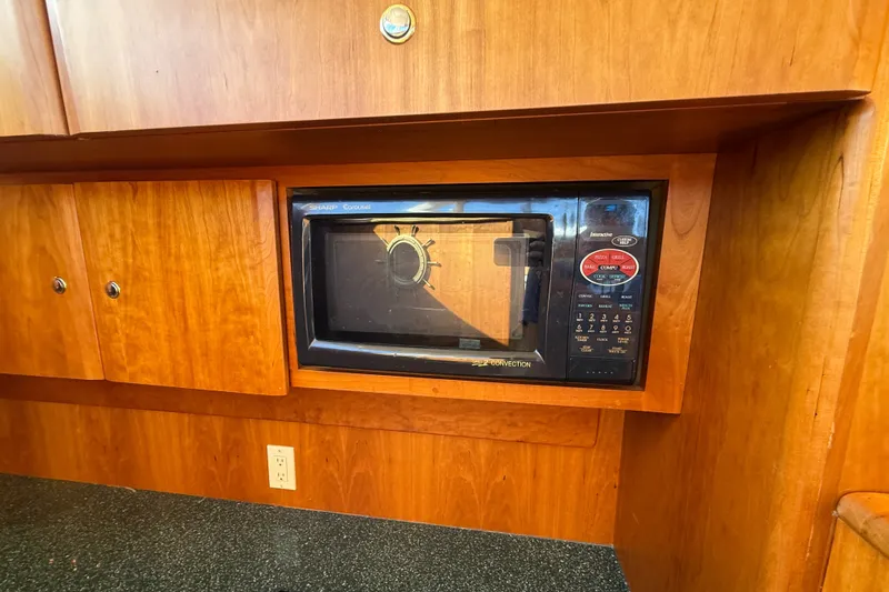 Slide: The Image of Microwave in 2000 Silverton 42 Convertible yacht kitchen with wooden cabinetry. - 24