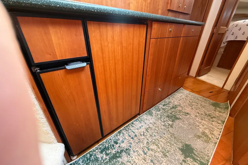 Slide: The Image of Interior of 2000 Silverton 42 Convertible yacht with wooden cabinetry and green countertop. - 29