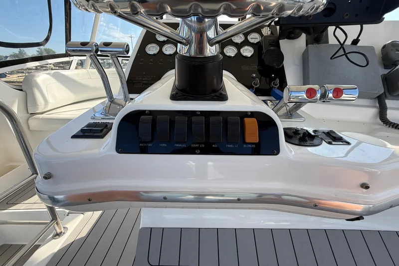 Slide: The Image of Control panel of a 2000 Silverton 42 Convertible yacht with switches and throttle levers. - 56
