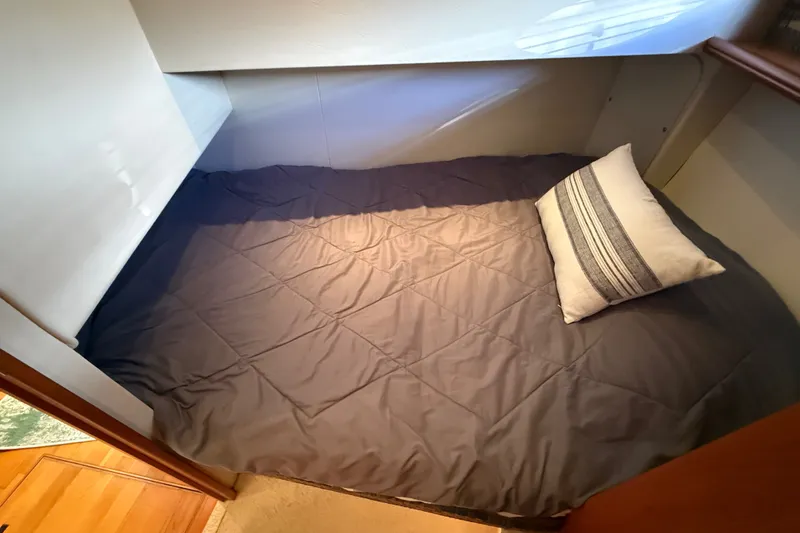 Slide: The Image of Cozy sleeping area in a 2000 Silverton 42 Convertible yacht with pillow and bedding. - 33