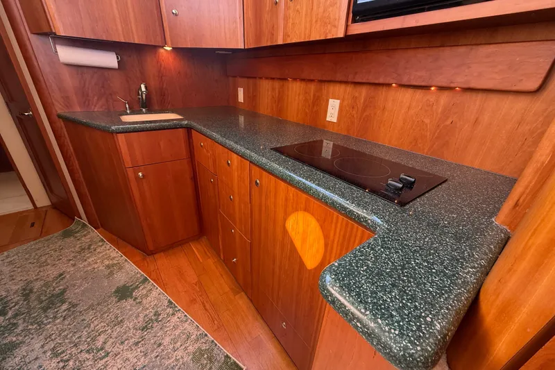 Slide: The Image of Kitchen area of a 2000 Silverton 42 Convertible yacht with wood cabinetry and modern appliances. - 22