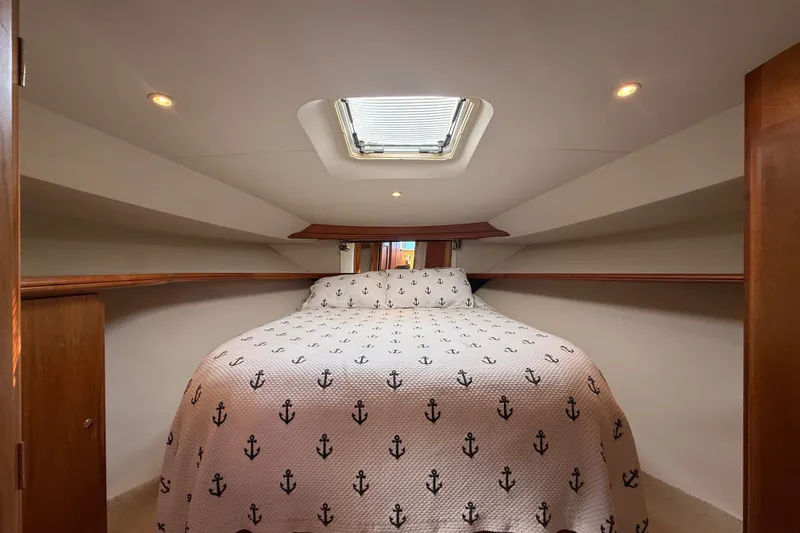 Slide: The Image of Cozy cabin interior of 2000 Silverton 42 Convertible yacht with anchor-patterned bedding. - 35