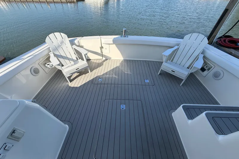 Slide: The Image of Spacious deck of 2000 Silverton 42 Convertible with Adirondack chairs, overlooking calm waters. - 13