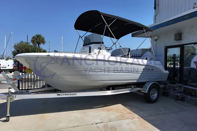 The Image of A white Stingray 17 CC boat from 2027 sits on a trailer at a yacht basin. - 1