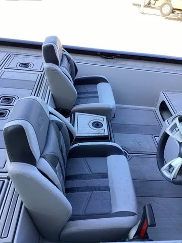 Slide: The Image of Two cushioned seats in a modern boat with gray accents and a central cup holder. - 29