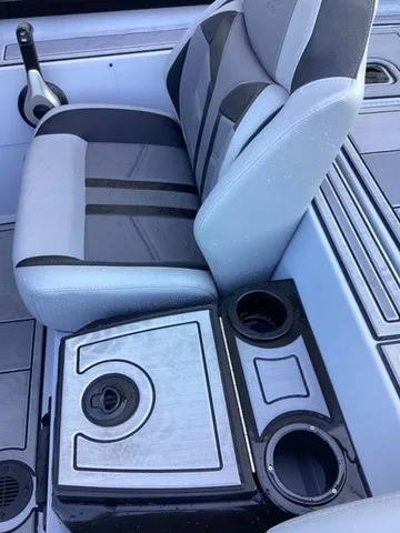 Slide: The Image of A gray boat seat with black stripes and an integrated cup holder. - 13