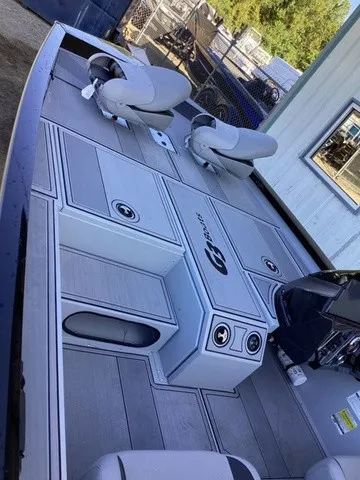 Slide: The Image of The image shows the deck of a G3 Sportsman 1810 SE boat with gray seats and storage. - 40