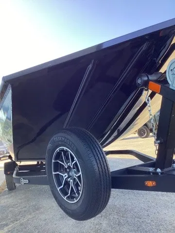 Slide: The Image of A black boat on a trailer with a spare tire. The sky is clear and blue. - 21