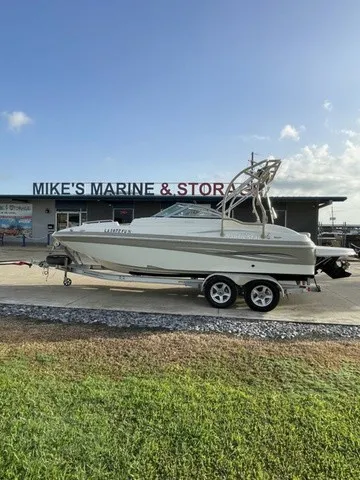 The Image of A 2008 NauticStar 232 D/C boat on a trailer in front of a store labeled "Mike's Marine & Store." - 1