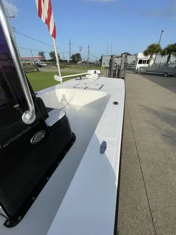Slide: The Image of A 2019 Topwater Skiffs FS190 with a white deck and black console, parked on a concrete lot. - 14