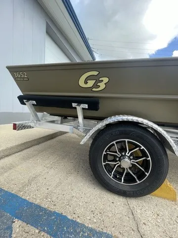 Slide: The Image of A G3 Gator Tough 1652 VBW boat on a trailer, partially visible, with a building in the background. - 2
