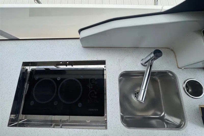 Slide: The Image of Modern kitchen area on 2021 Jeanneau NC Weekender 1095 with stove and sink. - 31