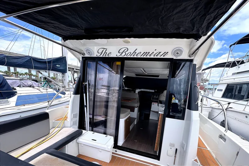 Slide: The Image of El Jeanneau NC Weekender 1095 de 2021 tiene un salón abierto con puertas correderas de vidrio y asientos exteriores. - 17