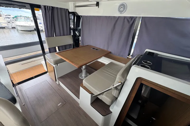Slide: The Image of Interior of 2021 Jeanneau NC Weekender 1095 with seating and table, dockside view. - 27