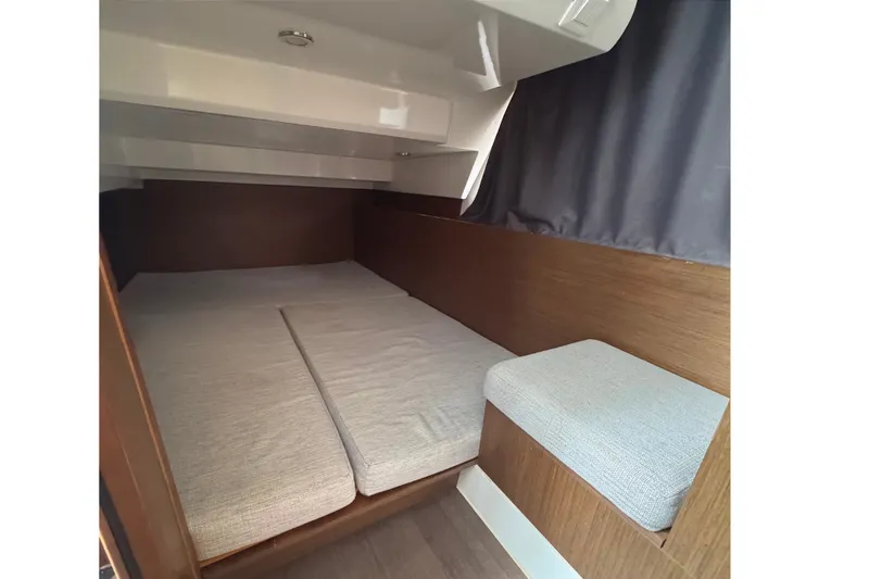Slide: The Image of 2021 Jeanneau NC Weekender 1095 cabin interior with cozy bedding and wooden accents. - 42
