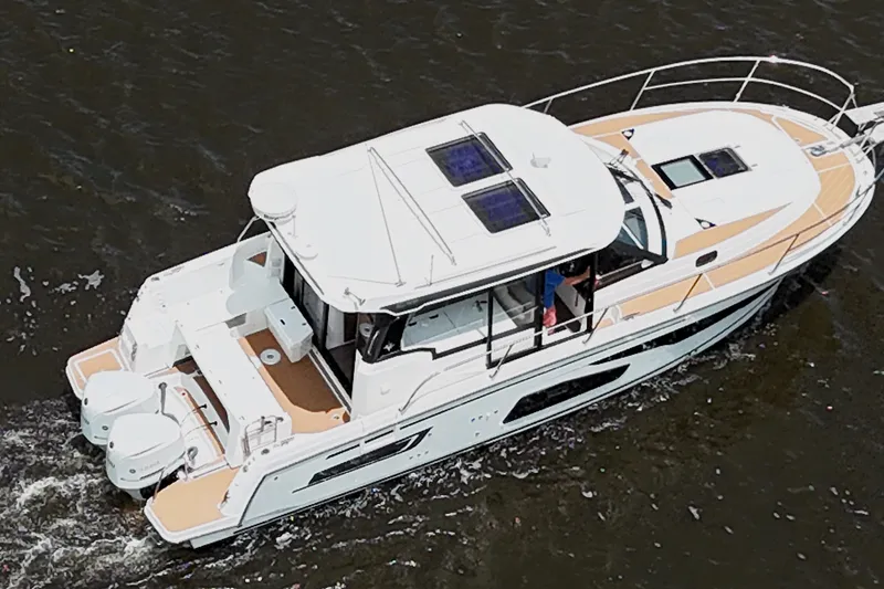 Slide: The Image of 2021 Jeanneau NC Weekender 1095 cruising on water, aerial view. - 10