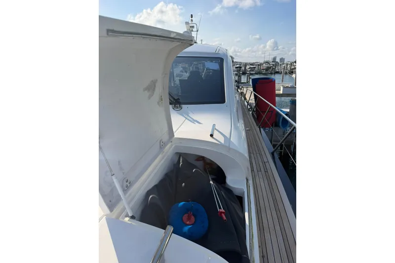 Slide: The Image of 2005 Princess V70 yacht docked, open storage compartment, sunny marina background. - 17