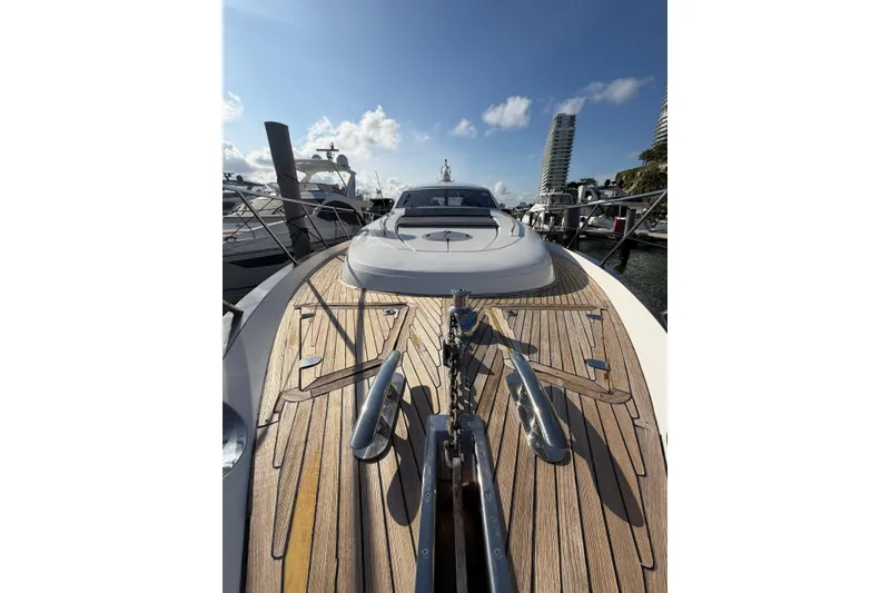 Slide: The Image of Luxury 2005 Princess V70 yacht with sleek wooden deck, docked in marina under blue sky. - 4