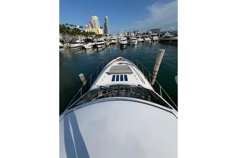 Slide: The Image of 2005 Princess V70 yacht docked in a marina with city skyline background. - 6