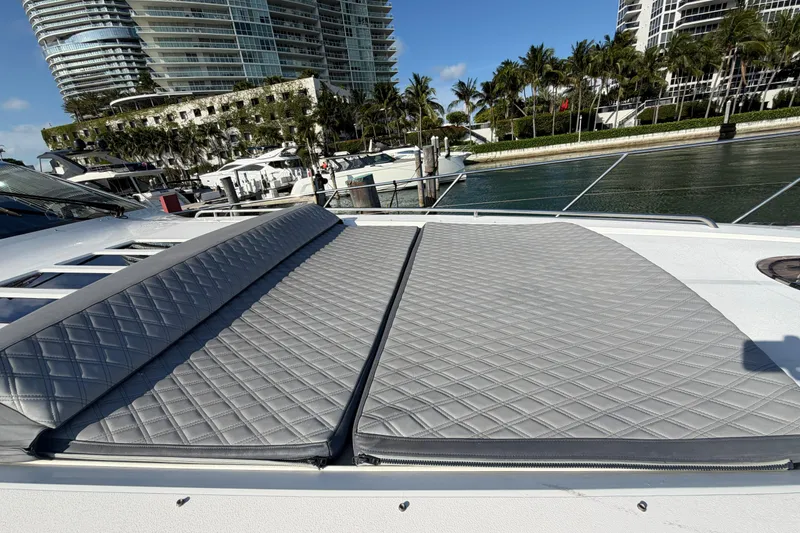 Slide: The Image of Luxury yacht Princess V70 2005 with quilted sunbed, docked near modern waterfront buildings. - 8
