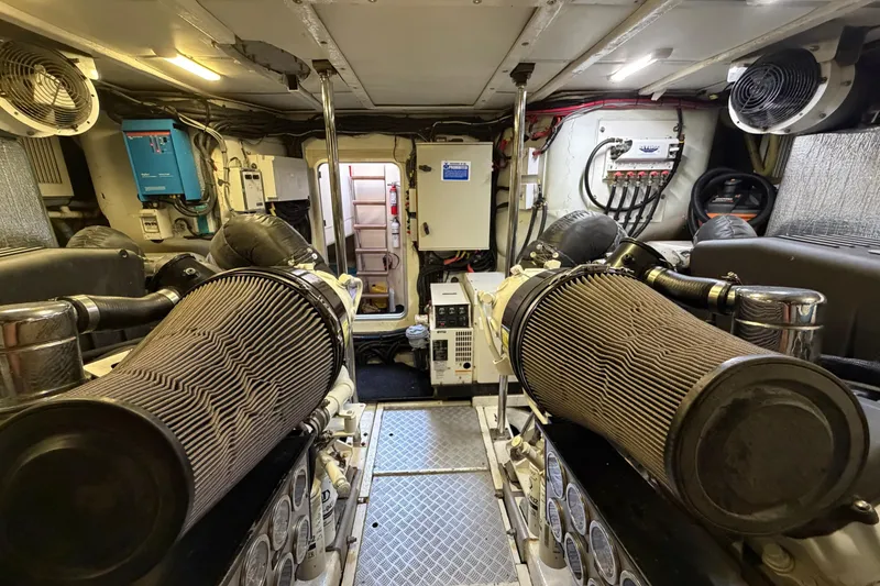 Slide: The Image of Engine room of a 2005 Princess V70 yacht, featuring dual air filters and control panels. - 23