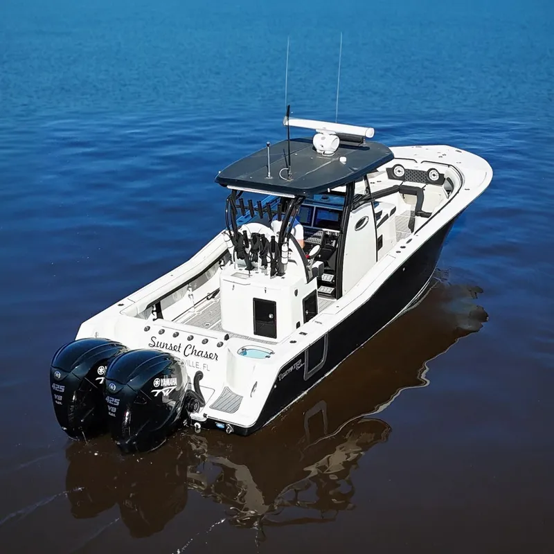 Slide: The Image of 2023 Tidewater 320 CC Adventure boat on calm water, featuring dual Yamaha engines. - 2