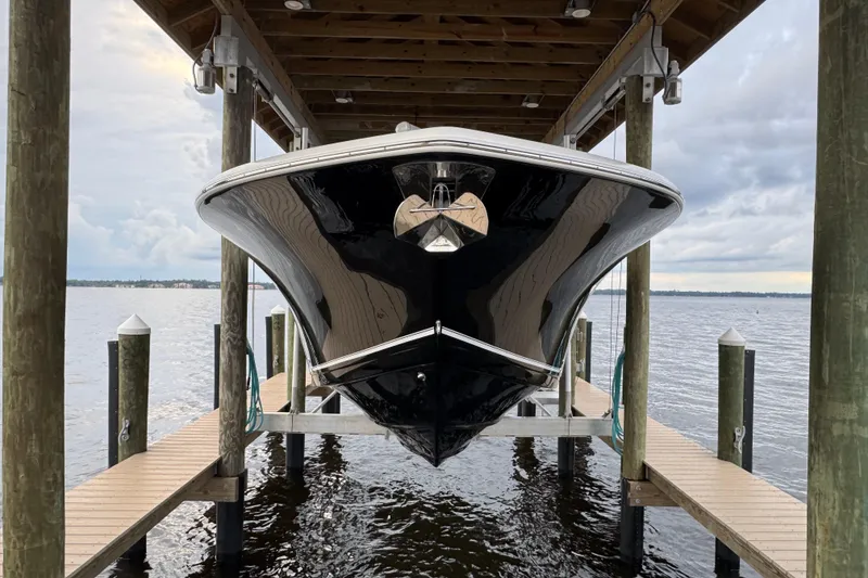 Slide: The Image of 2023 Tidewater 320 CC Adventure boat docked under a wooden shelter. - 15