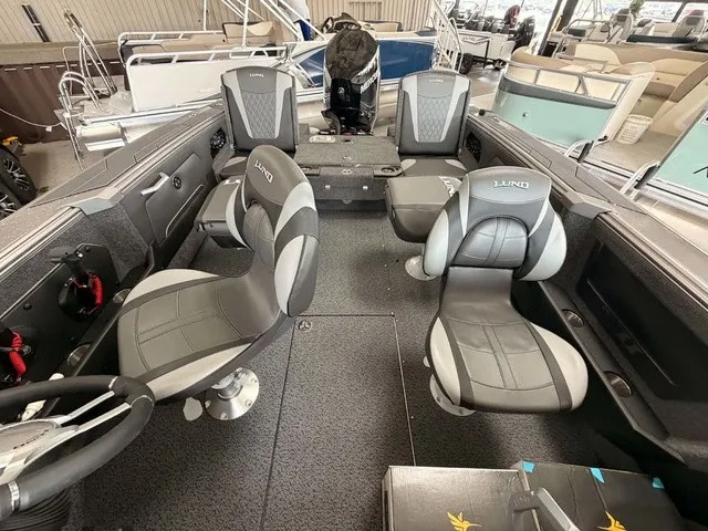 Slide: The Image of The image shows the interior of a Lund 1875 Tyee SS boat with gray seats and a helm. - 7