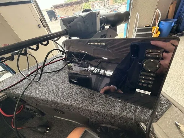 Slide: The Image of A modern fish finder device is mounted on a gray carpeted surface, surrounded by cables and boat equipment. - 5