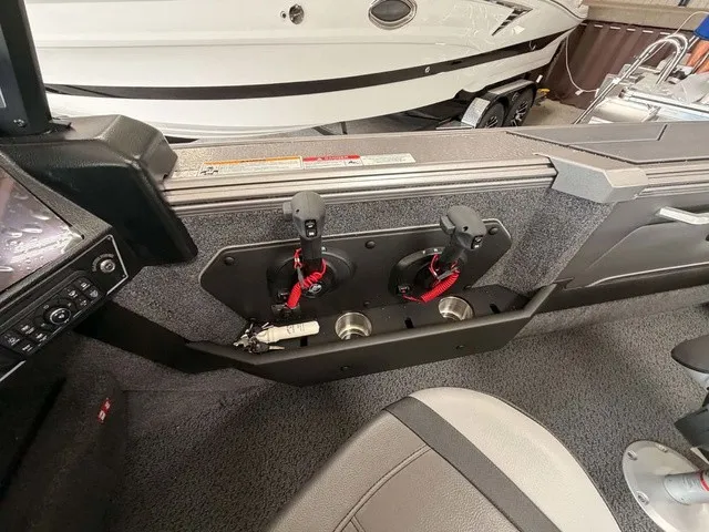 Slide: The Image of The image shows the interior of a Lund 1875 Tyee SS boat with cup holders and control levers. - 10
